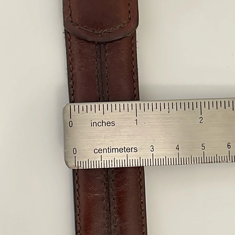 Brown leather belt with center stitch details. Size 32. ‎ Solid brass buckle.